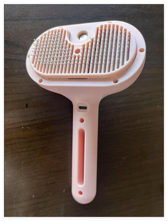 Self-cleaning button on pet grooming brush ejecting collected fur