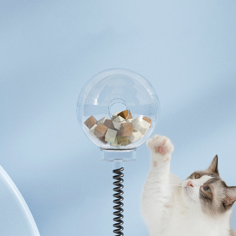 SpringSnack 2-in-1 spring toy lifestyle shot — cat playing with bouncing spring treat dispenser at home

